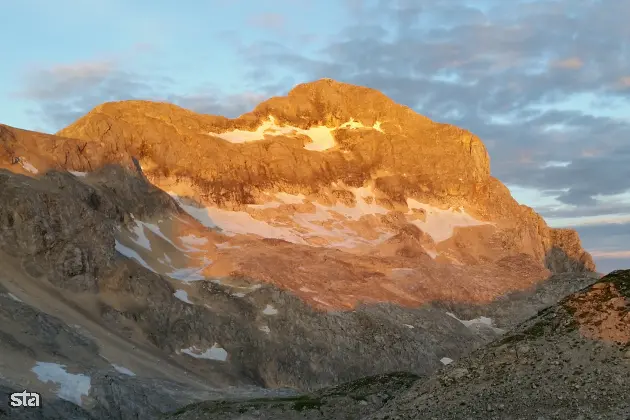 Julijske Alpe. Sončni vzhod, Triglav (2864 m) in spodaj Triglavski ledenik. Foto: Aljoša Rehar/STA Arhiv STA